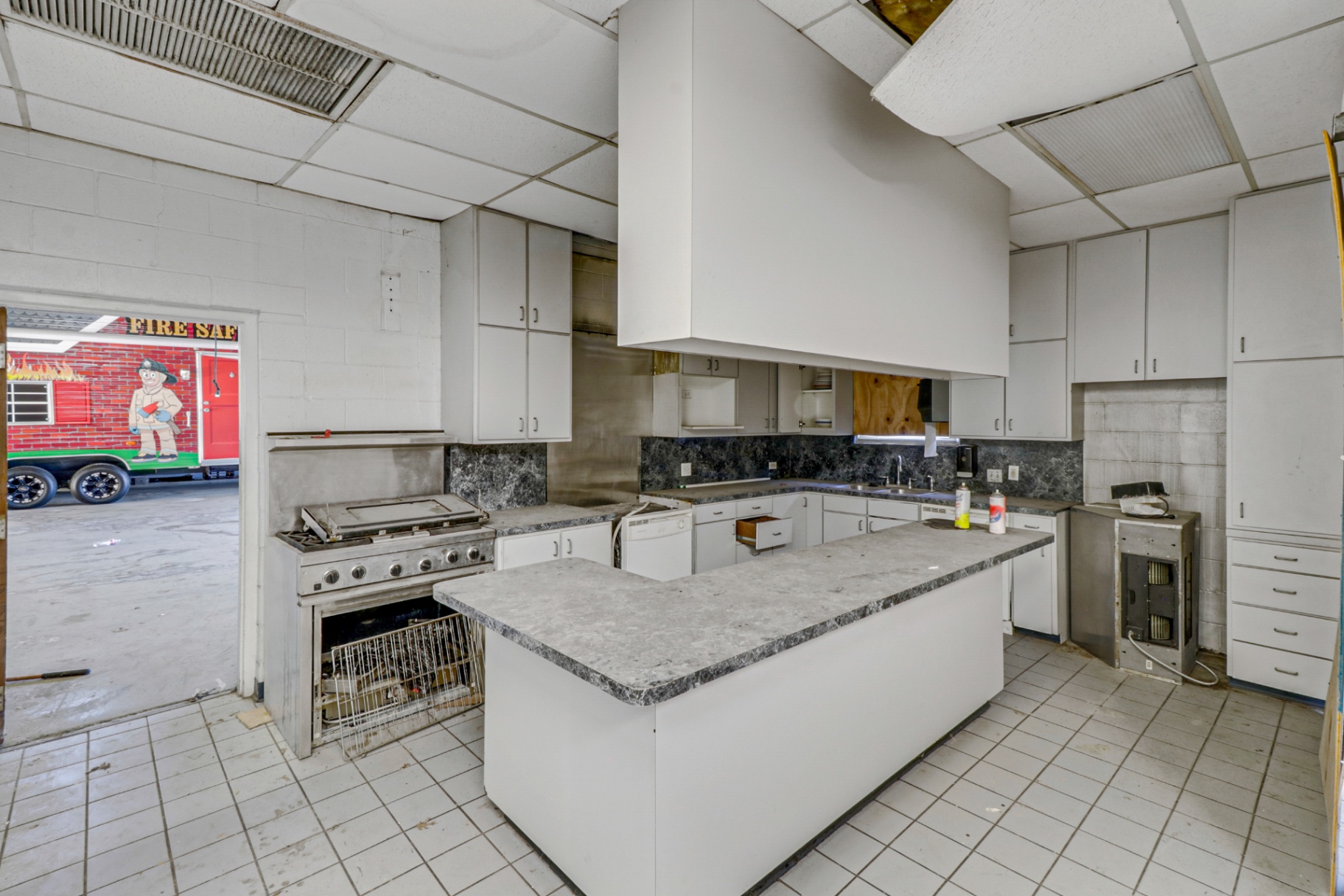 Original firehouse kitchen with commercial range and hood