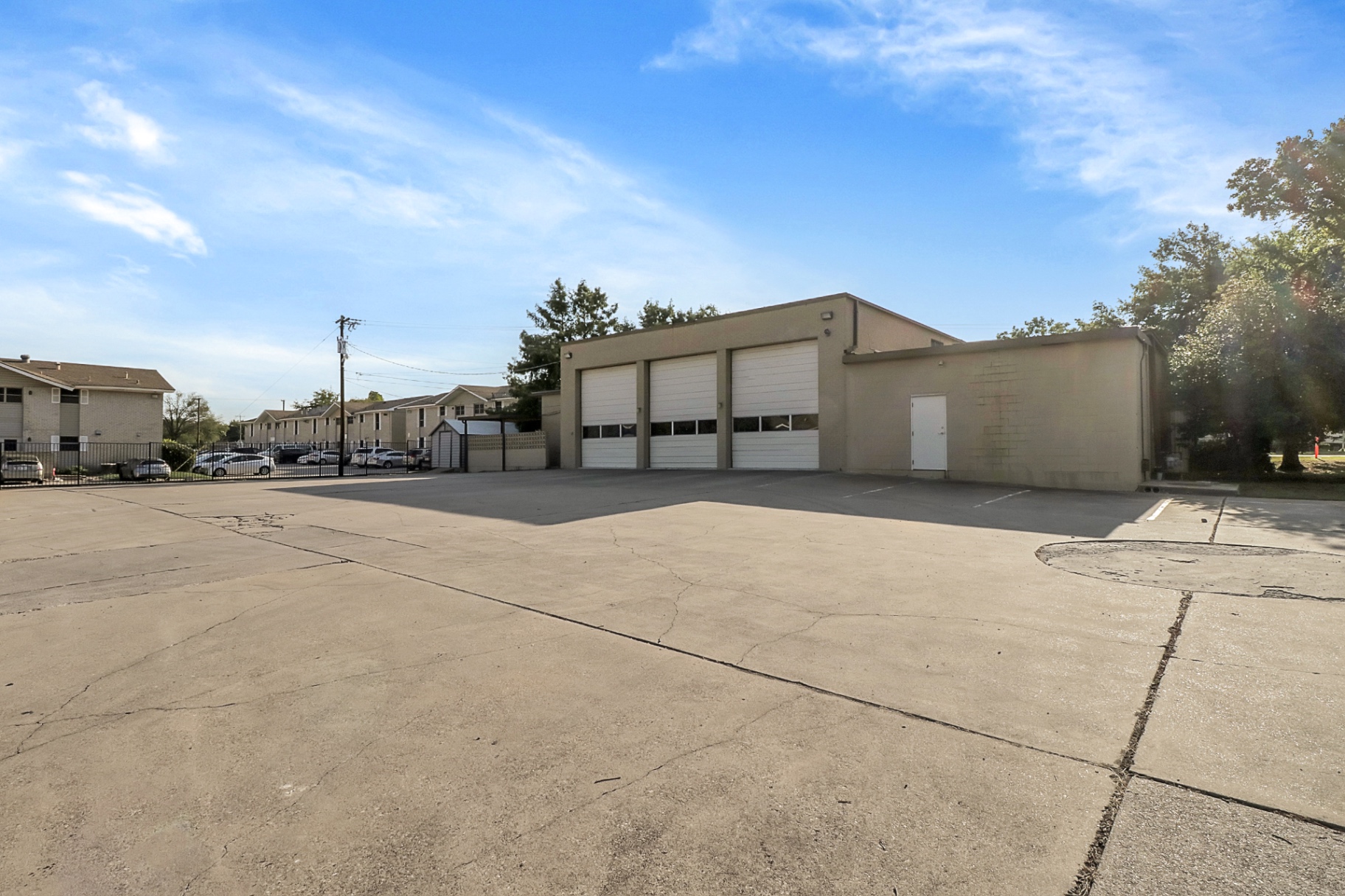 Wide rear view of the fire station with three bay doors and parking apron